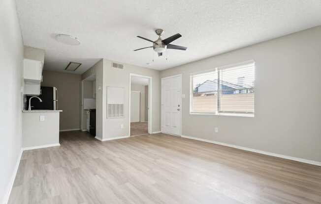 A spacious room with a ceiling fan and light fixture.