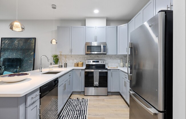 an open kitchen with stainless steel appliances and white cabinets