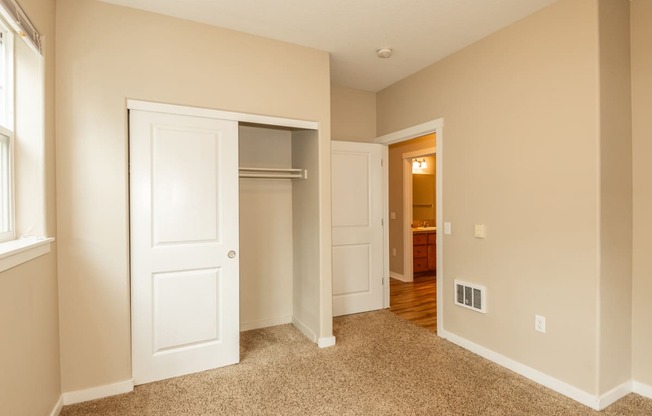 a bedroom with an open door to a closet and a hallway to a bathroom