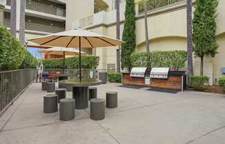 A patio with a table, chairs, and umbrella.