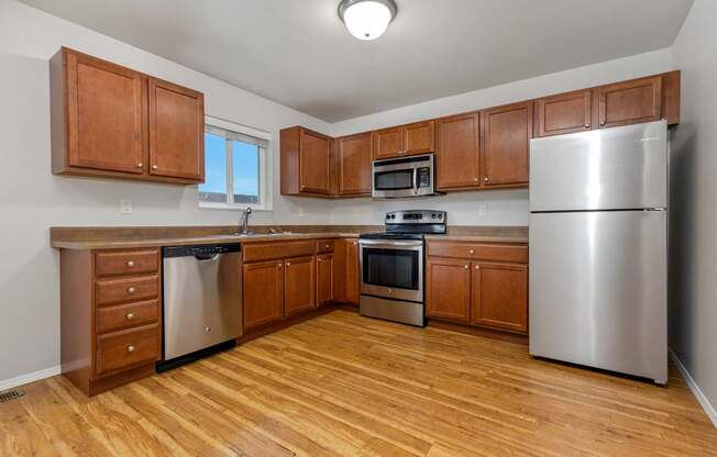 A kitchen with wooden cabinets and stainless steel appliances.