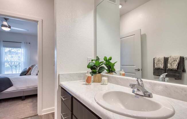 A bathroom with a marble countertop and a large mirror.