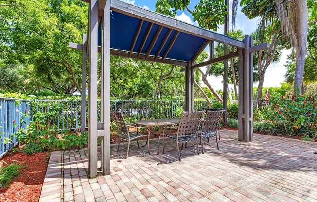 a patio with a picnic table and a pergola at Waterford Park Apartment Homes, LLC, Lauderhill, 33319