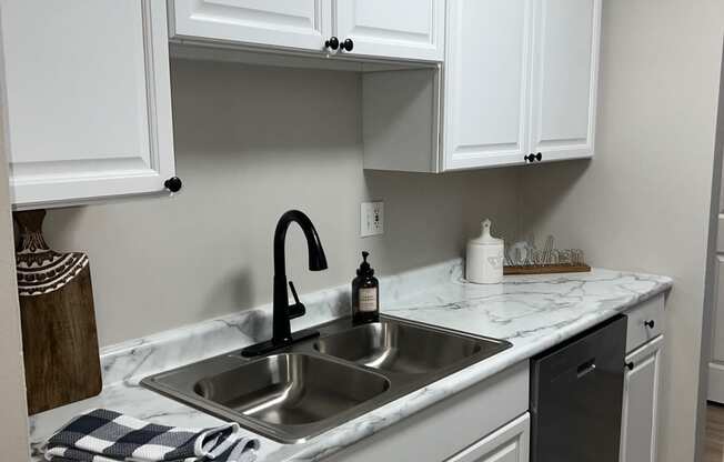 a kitchen with white cabinets and a sink