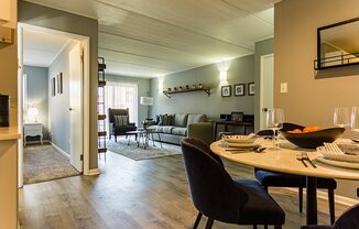 a living room and dining room with a table and chairs