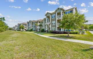 A grassy area in front of apartment buildings.