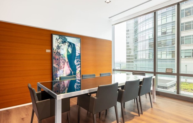 a conference room with a table and chairs and a painting on the wall