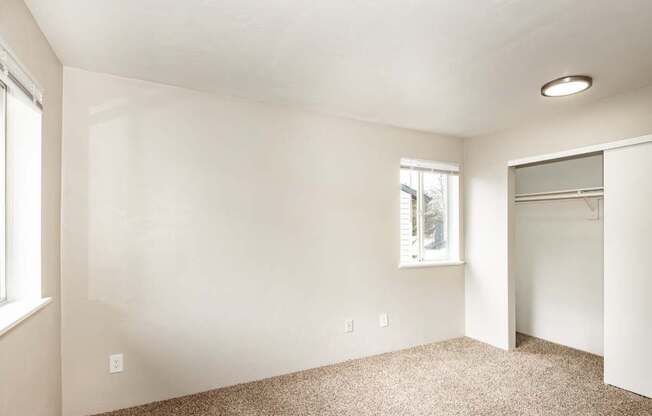 A room with a carpeted floor and a window.