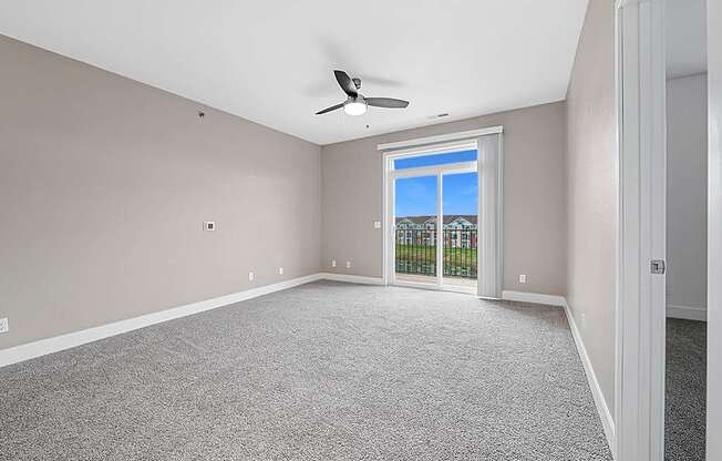 living room with a 9 foot ceiling leading to a balcony at Trade Winds Apartment Homes, Elkhorn, NE