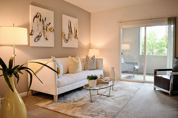 A living room with a white couch, a yellow vase, and two lamps.