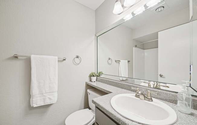 A white towel hangs on a towel rack in a bathroom.