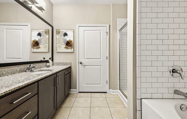 a bathroom with a sink and a shower and a white door