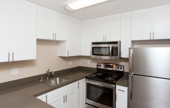 a kitchen with white cabinets and stainless steel appliances