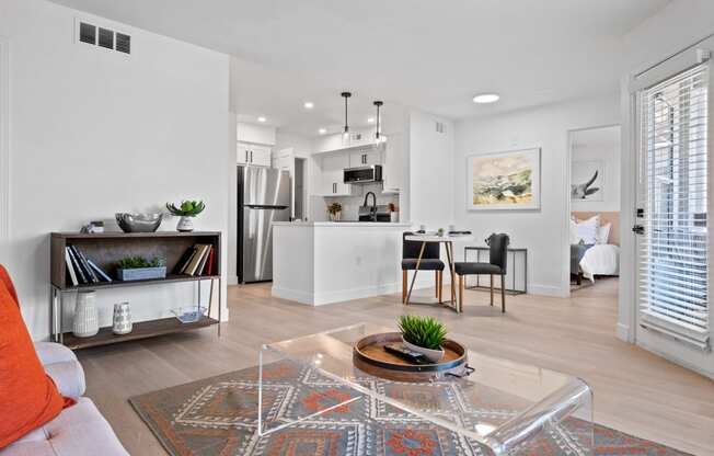 an open living room and kitchen with a table and chairs