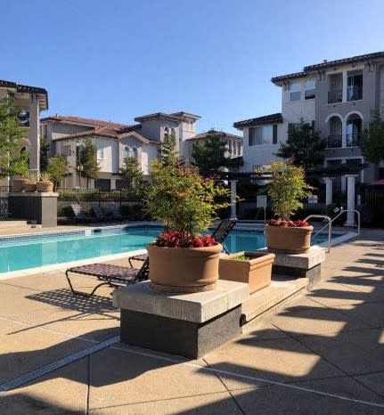 a swimming pool with a chaise lounge chair and potted plants  at Falcon Bridge at Gale Ranch, California