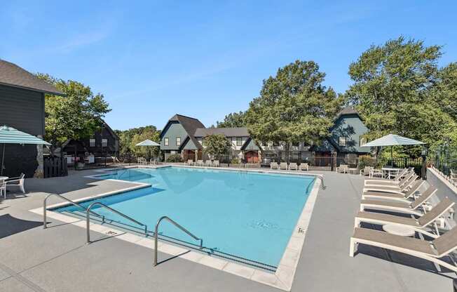 A large swimming pool surrounded by lounge chairs and umbrellas.