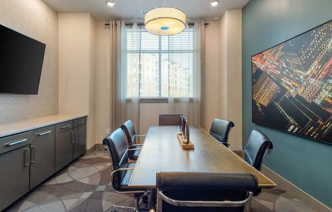 a conference room with a long table and chairs and a large painting on the wall