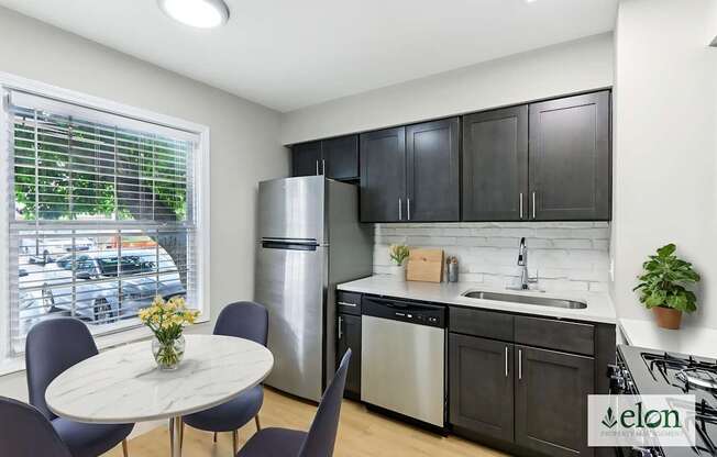 A modern kitchen with a dining table and chairs.