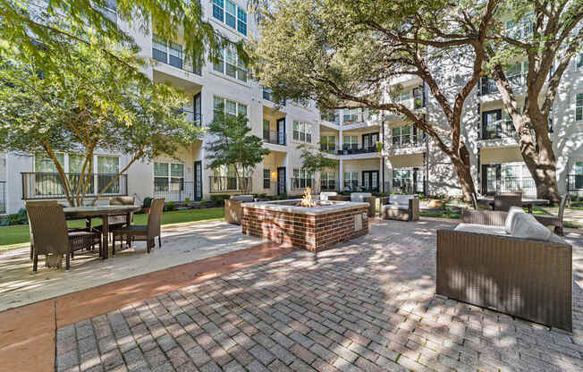 a courtyard with a fountain and tables and chairs in front of an apartment building