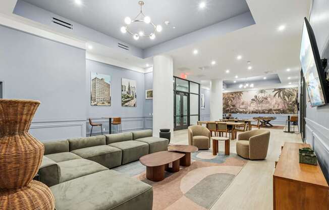 A spacious living room with a large wicker chair and a green sofa.