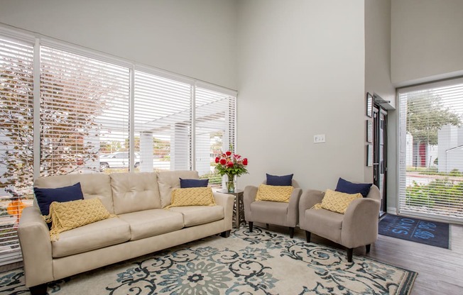 a living room with a couch and two chairs and a rug