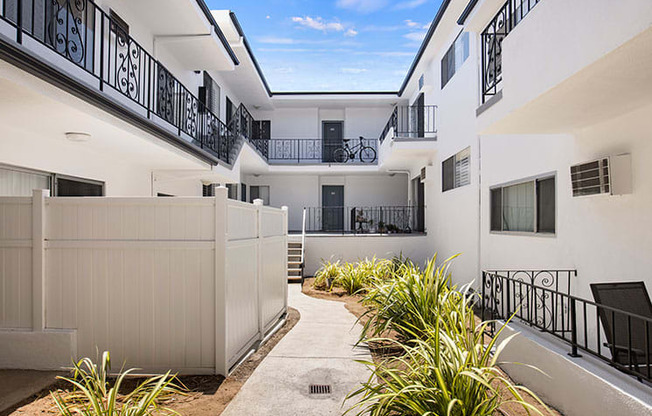 Green outdoor courtyard depicting access to walk-up units.