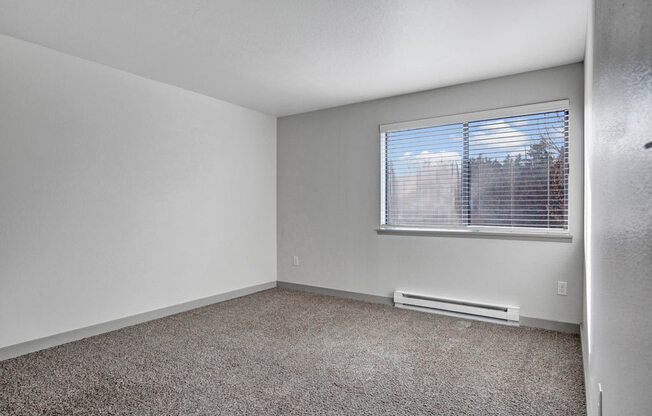 an empty bedroom with a large window