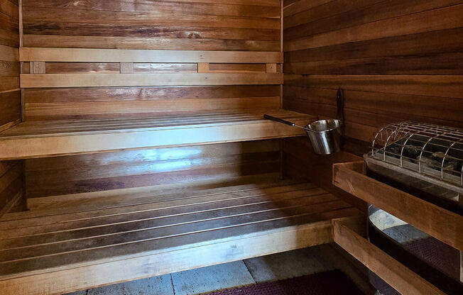 a wooden sauna with a metal pot on the side of it