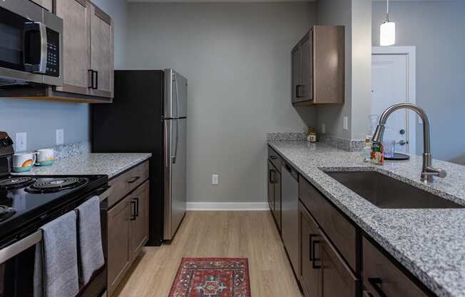 kitchen with granite countertops at the district flats apartments in lenexa, ks