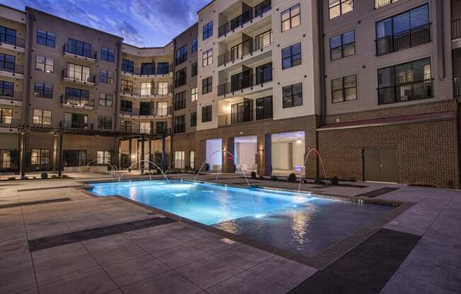 an apartment swimming pool in front of an apartment building
