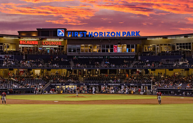 the sun sets over the stadium during a baseball game