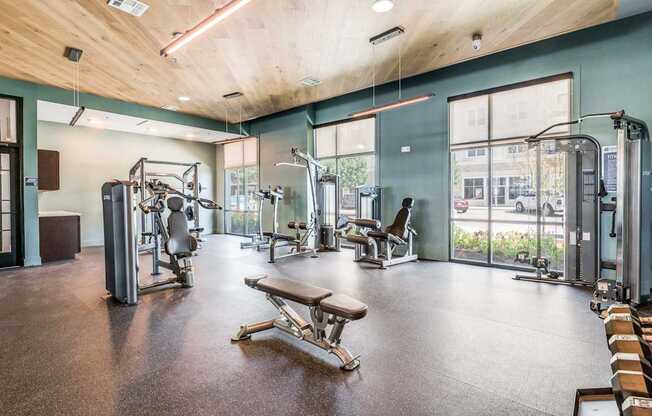 A gym with a variety of equipment including treadmills, weights, and exercise machines.