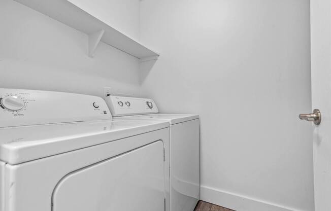 A white washing machine and dryer in a laundry room.