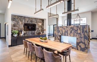 a dining room with a wooden table and chairs and a fireplace