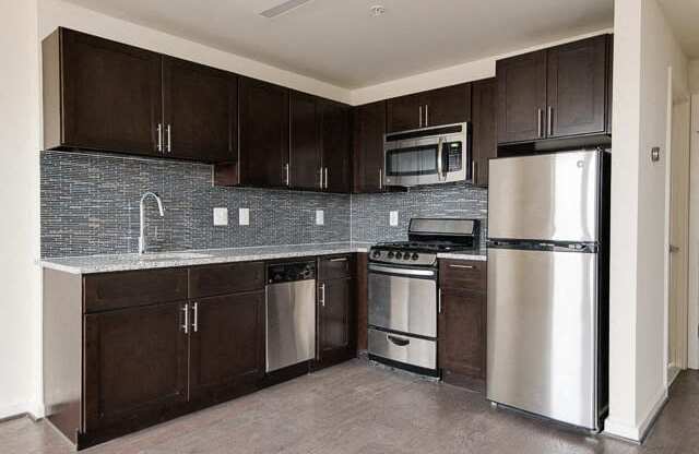 a kitchen with wooden cabinets and stainless steel appliances