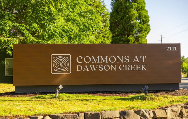 A brown sign with the words "Commons at Dawson Creek" on it.