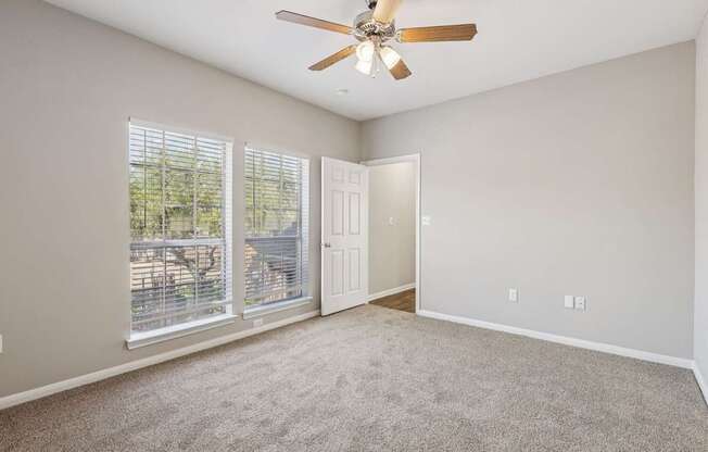 A room with a ceiling fan and a sliding glass door.
