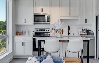 a white kitchen with a table and chairs and a microwave