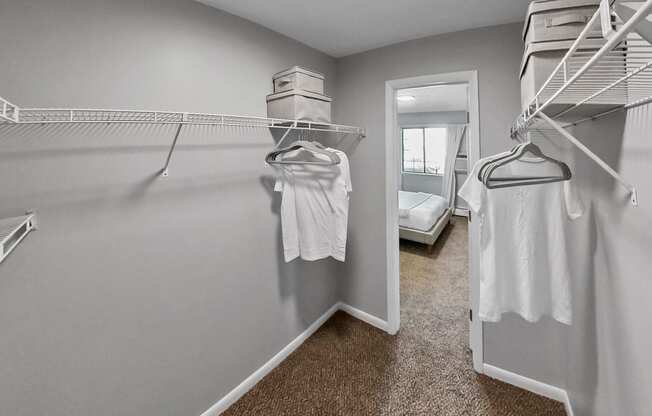 the walk in closet has two closets and two white dresses