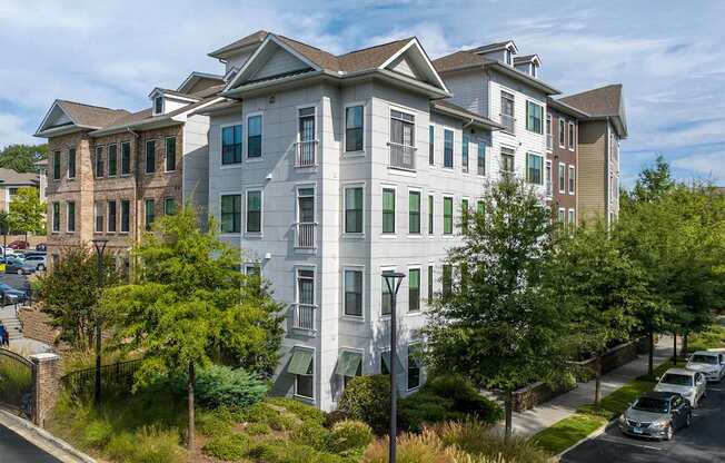 A white apartment building with a green lawn in front.