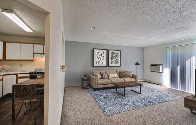 Open living room and kitchen with a couch and a table at Park Place Apartments in Fargo