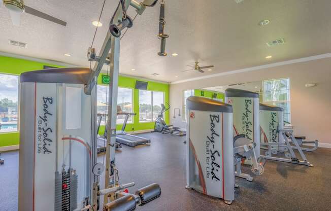 a gym with weights and other exercise equipment and windows