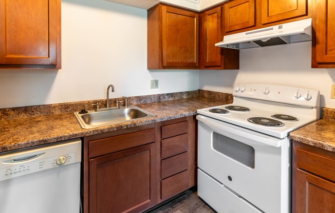 a kitchen with an oven sink and stove and cabinets