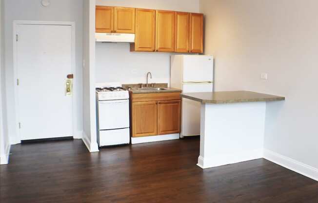 an empty kitchen with white appliances and wooden cabinets