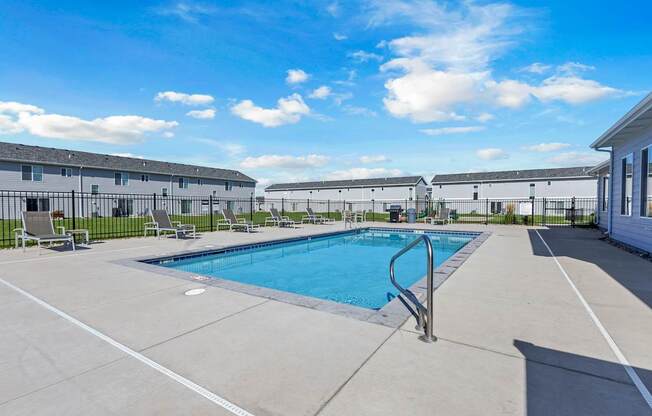 A swimming pool in a sunny outdoor setting.