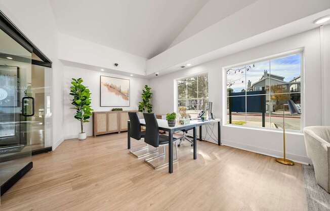 A modern home office with a desk, chair, and a large window.