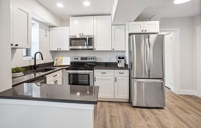 a kitchen with white cabinets and stainless steel appliances