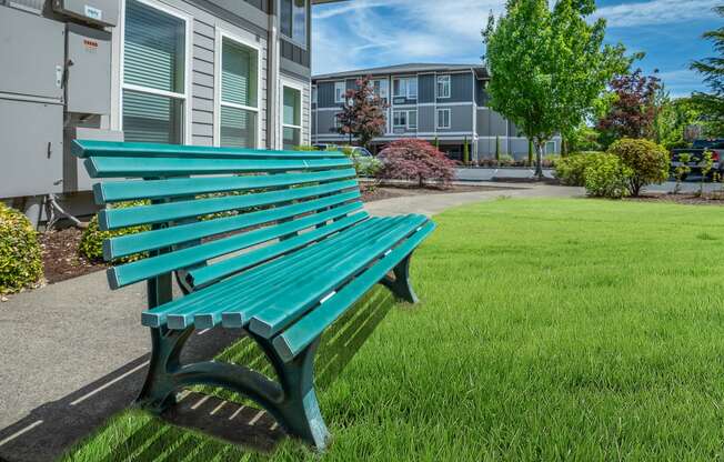 a green park bench in front of a building