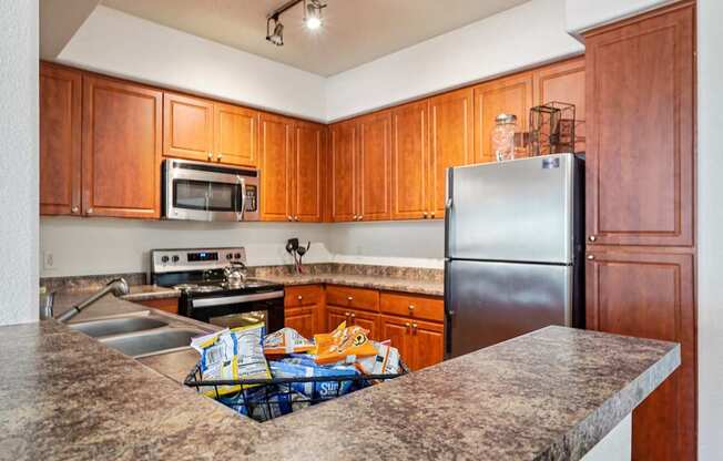 A kitchen with wooden cabinets and a granite countertop.