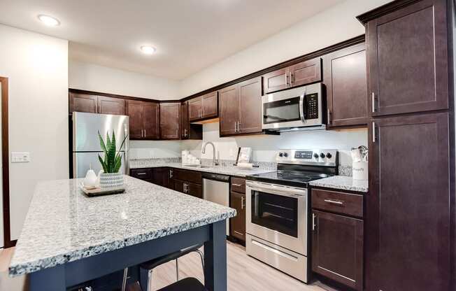 kitchen with espresso cabinetry and accent island at Lake Jonathan Flats, Chaska, Minnesota